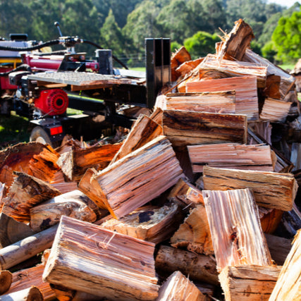 Wood Splitters / ChippersA stack of split wood next to a wood splitter.