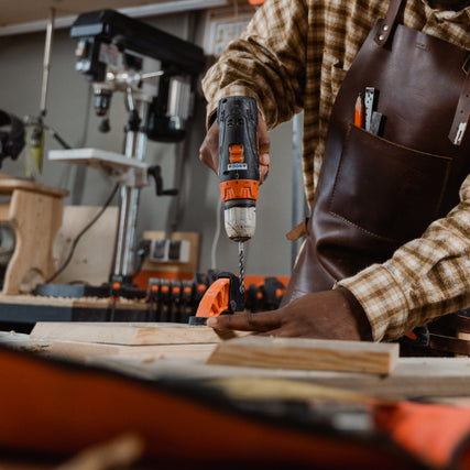 DIYA close-up of a power drill being used to pre drill a hole into lumber.
