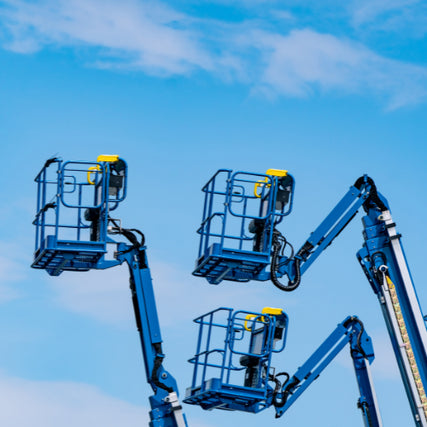 LiftsBlue boom lifts parked outside on a clear day.